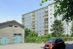 Schuppen / Garage mit grauer Putzfassade - Hochhaus / Wohnsiedlung in Wentorf bei Hamburg.