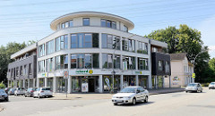 Halbrundes Eckgebäude - Gewerbeimmobilie, im Hintergrund ein Wohnhaus aus der Gründerzeit / historische und moderne Architektur an der Hamburger Landstraße.