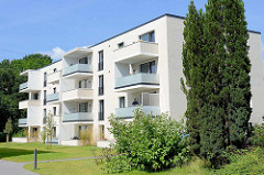 Weißer, kubischer Wohnblock mit teilweise überdachten Balkons - Architektur in Wentorf bei Hamburg.