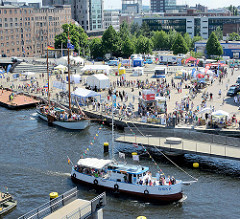 Luftaufnahme vom Binnenhafen in Hamburg Harburg - Blick auf den Kanalplatz und die Gebäude am Westlichen Bahnhofskanal. Die Fussgänger Drehbrücke über den Lotsekanal ist geöffnet, der Kutter Omka passiert die Durchfahrt.