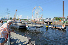 Die Drehbrücke / Fussgängerbrücke über den Lotsenkanal im Harburger Binnenhafen ist geöffnet; ein Festmacherboot passiert die Durchfahrt..