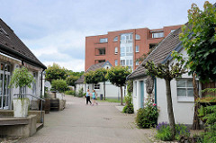 Wohnblock / Neubau und historische Deputatshäuser an der Dorfstraße in Glinde - in den 1970er Jahren konnte der Abriss der alten Häuser verhindert werden. Deputatshäuser wurden Landarbeitern für einen Teil ihres Lohns zur Verfügung gestellt.