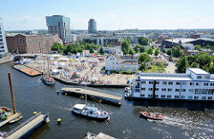 Luftaufnahme vom Binnenhafen in Hamburg Harburg - Blick auf den Kanalplatz und die Gebäude am Westlichen Bahnhofskanal. Die Fussgänger Drehbrücke über den Lotsekanal ist geöffnet, der Kutter Omka passiert die Durchfahrt.