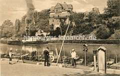 Travekanal in Lübeck - Ruderbootverleih am Kanalufer - ein Dampfschiff fährt qualmend unter Dampf Richtung Trave - am Ufer das Gebäude der Lübecker Navigationsschule / Seefahrtschule.