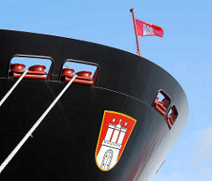 Seil und Schiffsbug des Containerschiffs "Hanover" am Hamburger Container Terminal Altenwerder; über dem Hamburg Wappen flattert die Hamburg Fahne im Wind.