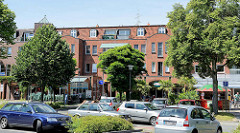 Geschäfts- und Wohnhaus, Neubau der 2000er Jahre - parkende und fahrende Autos / Straßenverkehr Hauptstraße in Wentorf.