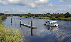 Der ehemalige Binnenhafenschlepper OMKA (hier ohne Mast)  auf einer Chartertour mit Gästen bei der Einfahrt in den Bergedorfer Schleusengraben. Der 1926 auf einer Hamburger Werft gebaute Schlepper hat bis 1990 in der DDR seinen Dienst getan.
