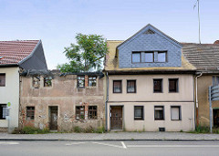 Wohnhäuser in der Lutherstadt Eisleben; neu + alt - restauriert und bewohnt / verfallen mit großem Baum im Dach.