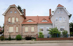 Doppelvilla in Oranienbaum - unterschiedliche Restaurierung, Fassadengestaltung und Vorgartenzaun.