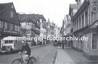 Die damalige Sachsenstrasse ca. 1936 ist mit Kopfsteinpflaster befestigt. Ein Lastwagen steht vor der Gaststätte Zum weissen Schwan. Eine Fahrradfahrerin überquert die Strasse - an dem Lenker des Fahrrads hängt eine Einkaufstasche.