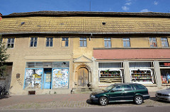 Historisches Lagergebäude, Geschäftshaus mit Dachlüftung und mit Steinen abgedeckten Dachfirst in der Köthener Straße von AKEN / Elbe.