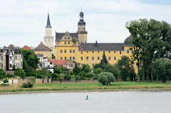Blick über die Elbe zum Coswiger Schloss. Coswig war von 1603 bis 1793 Teil des Fürstentums Anhalt-Zerbst. Das in der Stadt befindliche Schloss wurde 1667–1677 erbaut und diente bis ins 19. Jahrhundert als Witwensitz. Während im Bauschmuck des nördli