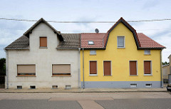 Doppelhaus mit unterschiedlicher Fensteranordnung und Farbgestaltung der Hausfassade - Architektur in Oranienbaum.
