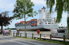 Das Containerschiff Jork verlässt die Schleuse in Brunsbüttel und fährt in den Nord-Ostsee-Kanal ein. Der Containerfeeder hat eine Länge von 134 m und eine Breite von 23 m; der Frachter hat eine Tragfähigkeit von 11 385 t und wurde 2001 auf der Sieta