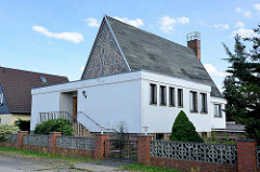 Ehm. Kirchengebäude der Neuapostolischen Kirche in Aken ( Elbe ), flacher Vorbau - farbiges Glasfenster / Schornstein.