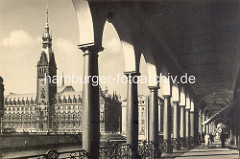 Säulengang der Alsterarkaden - Blick über die Kleine Alster zum Hamburger Rathaus.