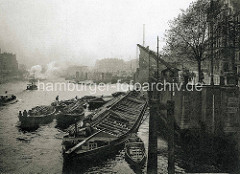 Alte Fotografie vom Hamburger Zollkanal bei den Mühren -  ein Elbkahn liegt an der Kaimauer - die Beladung erfolgt üer längsseits liegende Schuten.
