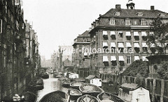 Historische Aufnahme vom Herrengrabenfleet in der Hamburger Neustadt - Hausboote ud Schuten im Fleet; ein Ewerführer stakt das Schiff auf dem Wasser. Re. das Gebäude vom Alten Waisenhaus, erbaut 1785 - Architekt Johannes Koop.