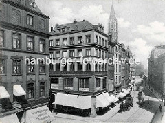 Geschäftshäuser / Kontorhäuser am Speersort - Geschäfte mit Markisen, Herrenmode Magazin - Jockey Club; Pferdefuhrwerke und Droschken auf der Straße - Kirchturm der St. Jacobi Kirche.
