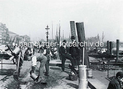 Alte Hafenszene an den Hamburger Vorsetzen am Binnenhafen - ein Milchhändler spült seine Milchkannen aus - im Hintergrund Wohngebäude an den Vorsetzen und Speichergebäude der Speicherstadt.