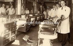 Historische Fotografie aus einem Friseursalon in der Hamburger Neustadt - Friseurstühle mit Lederkissen und Armlehne - Angestellte / Friseure mit weissen Kitteln.