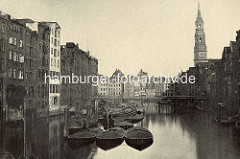 Historische Foto vom der Holzbrücke über den Nikolaifleet zur Hamburger St. Katharinenkirche.  Schuten mit Kohleladung liegen an Dalben, dahinter die hölzerne Reimersbrücke.