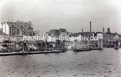 Alte Ansicht der Fischauktionshalle in Altona - Anleger mit Booten am Elbufer; re. im Hintergrund der Kirchturm der St. Pauli Kirche.