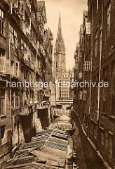 Foto vom historischen Hamburg - im Steckelhörnfleet liegen abgedeckte Schuten - geöffnete Fenster in den Wohnhäuser, Wäsche zum Trocknen hängt vor den Fenstern. Im Hintergrund die Reimersbrücke und der Kirchturm der St. Nikolaikirche.