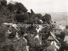 Historische Fotografie von Wohnhäusern - Reetdachhäusern im Treppenviertel von Hamburg Blankenese - im Hintergrund die Elbe.