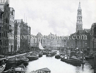 Alte Fotografie vom Nikolaifleet in der Altstadt Hamburgs - Schuten und Ewer liegen am Fleet; Speichergebäude und Kontorhäuser, Kirchturm der Sankt Katharinenkirche.