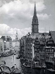 Blick von der Hohen Brücke auf das Nikolaifleet in der Alstadt Hamburgs - re. Rückseite von Speichergebäuden an der Grimm - im Hintergrund ein Ausschnitt der Holzbrück und der Turm vom Hamburger Rathaus - re. der Kirchturm der St. Nikolaikirche