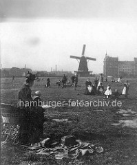 Altes Bild vom Hamburger Heiligengeistfeld - Frau mit Kinderwagen macht Picknick - Windmühle im Hintergrund.