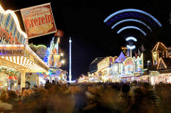 Hamburger Dom bei Nacht, Langzeitbelichtung; Stand mit Brezeln - Riesenschaukel in Bewegung.