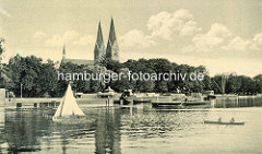 Ansicht vom alten Neuruppin - Blick vom Ruppiner See auf die Uferpromenade und Booten auf dem Wasser - Kirchtürme der St. Trinitatiskirche.