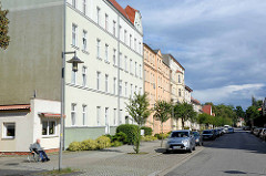 Mehrstöckige Wohnhäuser in der Bahnhofstraße in Neuruppin - im Vordergrund ein niedriges Flachdachgebäude, ehem. Laden.