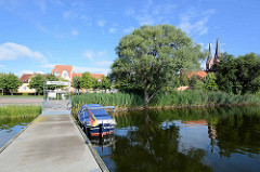 Städtischer Bootsanleger am Ruppiner See bei der Seepromenade von Neuruppin - re. die Kirchtürme der Kirche St. Trinitatis.