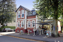 Gründerzeitgebäude mit Wohnungen - Anbau für Fischdelikatessen - Tische für Mittagstisch im Freien; Glißmannweg in Hamburg Schnelsen.