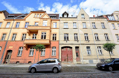 Mehrstöckige Wohnhäuser in Neuruppin - Gründerzeitarchitektur / Jugendstil; unterschiedlicher Zustand der Renovierung / Fassadengestaltung.