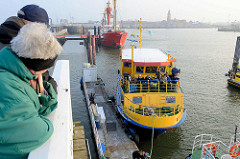 Ein Ausflugsschiff legt an der Alten Liebe in Cuxhafen an - im Hintergrund das Feuerschiff Elbe 1.