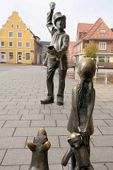 Skulptur der Utröper / Ausrufer, Bildhauer Frijo Müller-Belecke am Kirchplatz in Otterndorf - im Hintergrund das gelbe Barockgiebelhaus, eines der ältesten Wohnhäuser der Stadt - erbaut 1731,