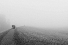 Spaziergang im Herbst auf dem Deich in Otterndorf - Spaziergänger verschwinden im Nebel.