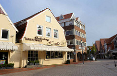 Wohn- und Geschäftshäuser unterschiedlicher Bauformen am Kirchplatz in Otterndorf.