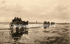 Altes Bild von Wattwagen auf dem Weg durch das Watt Richtung Insel Neuwerk - im Hintergrund die Insel mit Leuchtturm.