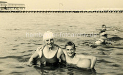 Altes Foto - Badeszene in Duhnen, Menschen im Wasser; im Hintergrund die hölzerne Badebrücke.