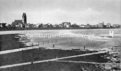 Hochwasser am Deich von Cuxhaven - altes Foto der Stadt, Blick auf die Häuser hinter dem Deich und den Kirchturm der Marine-Garnisionskirche.