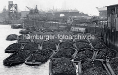 Gleisanlagen der Hafenbahn am Kirchenpauerkai im Hamburger Hafen. Waggons mit Kohle werden auf Schuten entladen.