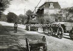 Historische Aufnahme von der Kaistraße / Elbberg in Hamburg Altona - ein Zugwagen der elektrifizierten Hafenschleppbahn zieht / unterstützt ein Pferdefuhrwerk bei seiner Fahrt bergauf; ein Fahrradfahrer sieht zu .