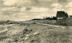 Alte Fotografie von der Nordseeküste bei Duhnen - Ferienhaus mit Reet gedeckt, im Hintergrund die Badebrücke.