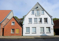 Historisches Wohnhaus mit Dachwinde und zur Wohnung umgebautem Dachspeicher - lks. kleines einfaches Wohngebäude mit roter Ziegelfassade - Architektur in Otterndorf.