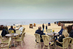 Herbsttag am Strand von Duhnen / Cuxhafen - Café mit Korbstühlen an der Nordsee; leere Strandkörbe, einige Spaziergänger.